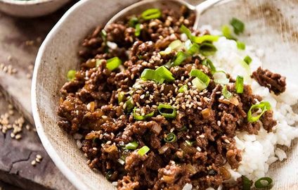 Asian Beef Bowls (ground beef recipe) served over rice garnished with scallions, ready to be eaten