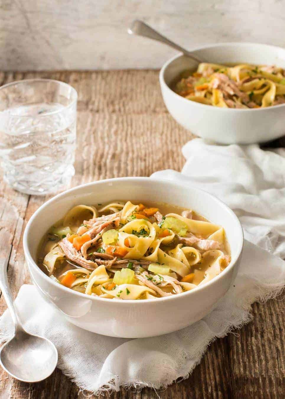 An easy Chicken Noodle Soup in a white bowl, ready to be eaten.