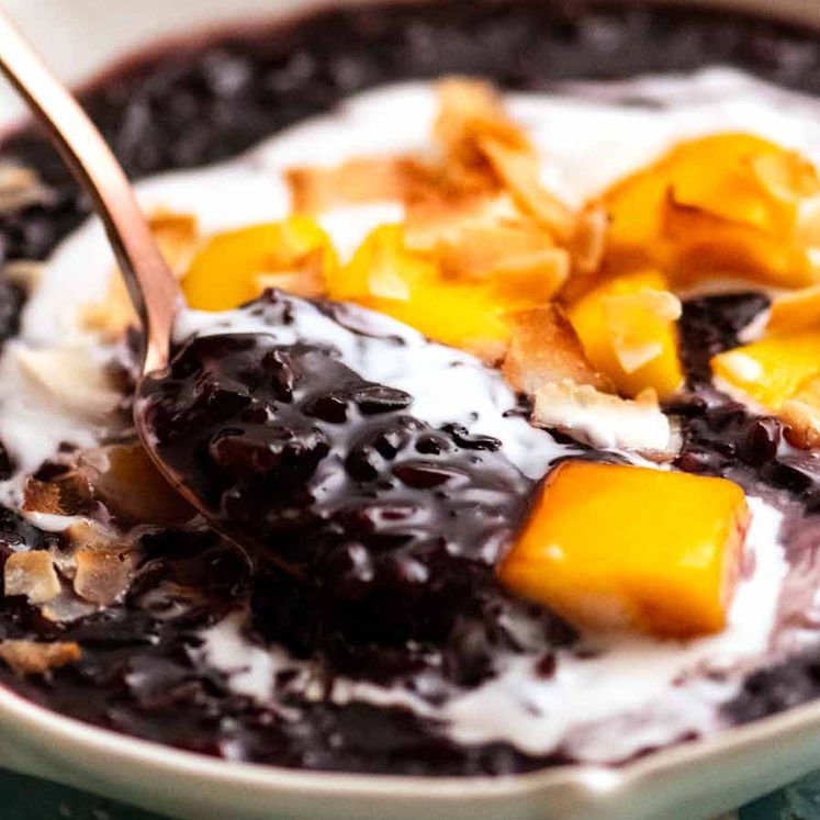 Close up of spoon scooping up Thai Black Sticky Rice Pudding