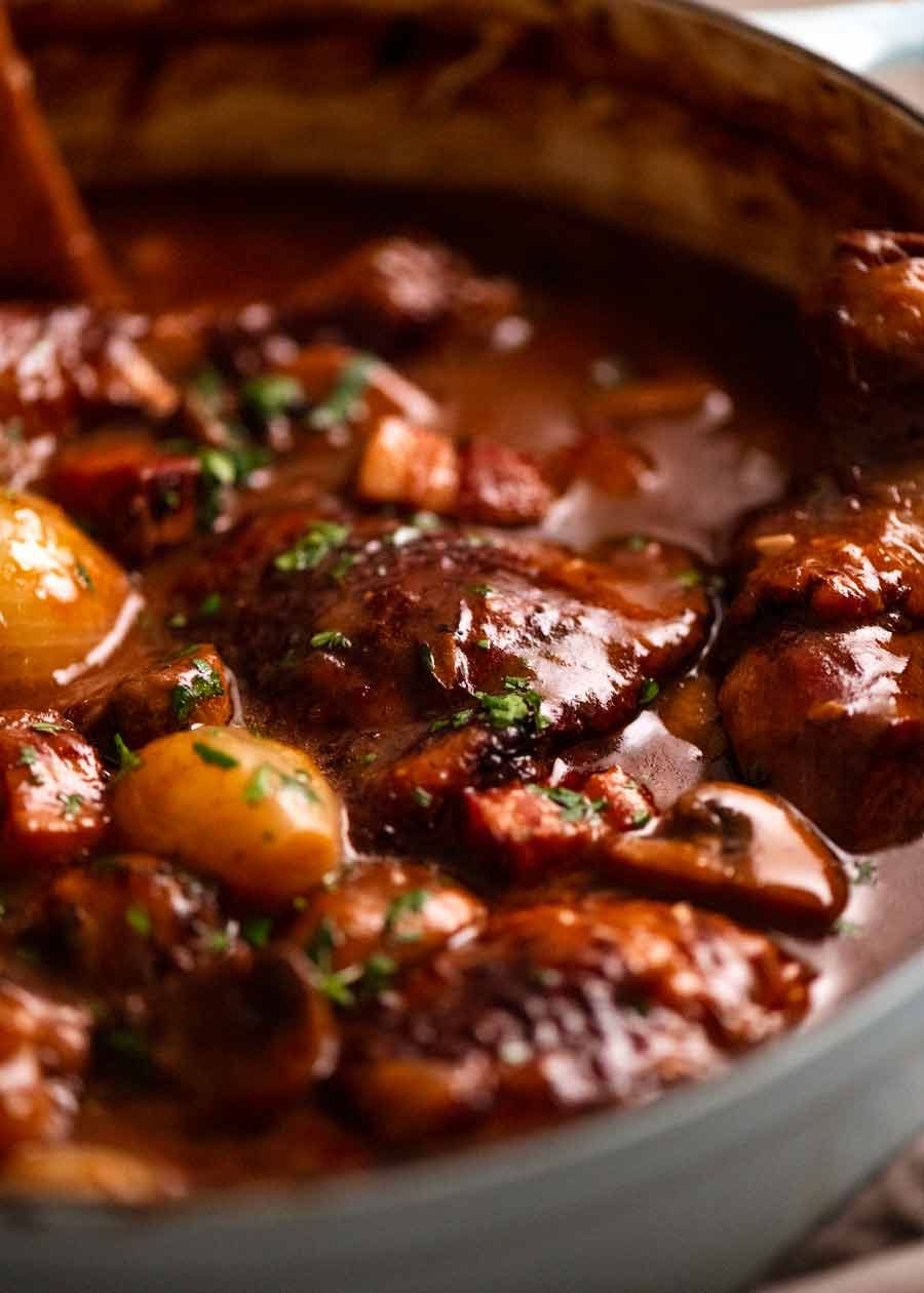 Close up photo of Coq au Vin - French chicken stew in a pot, fresh off the stove