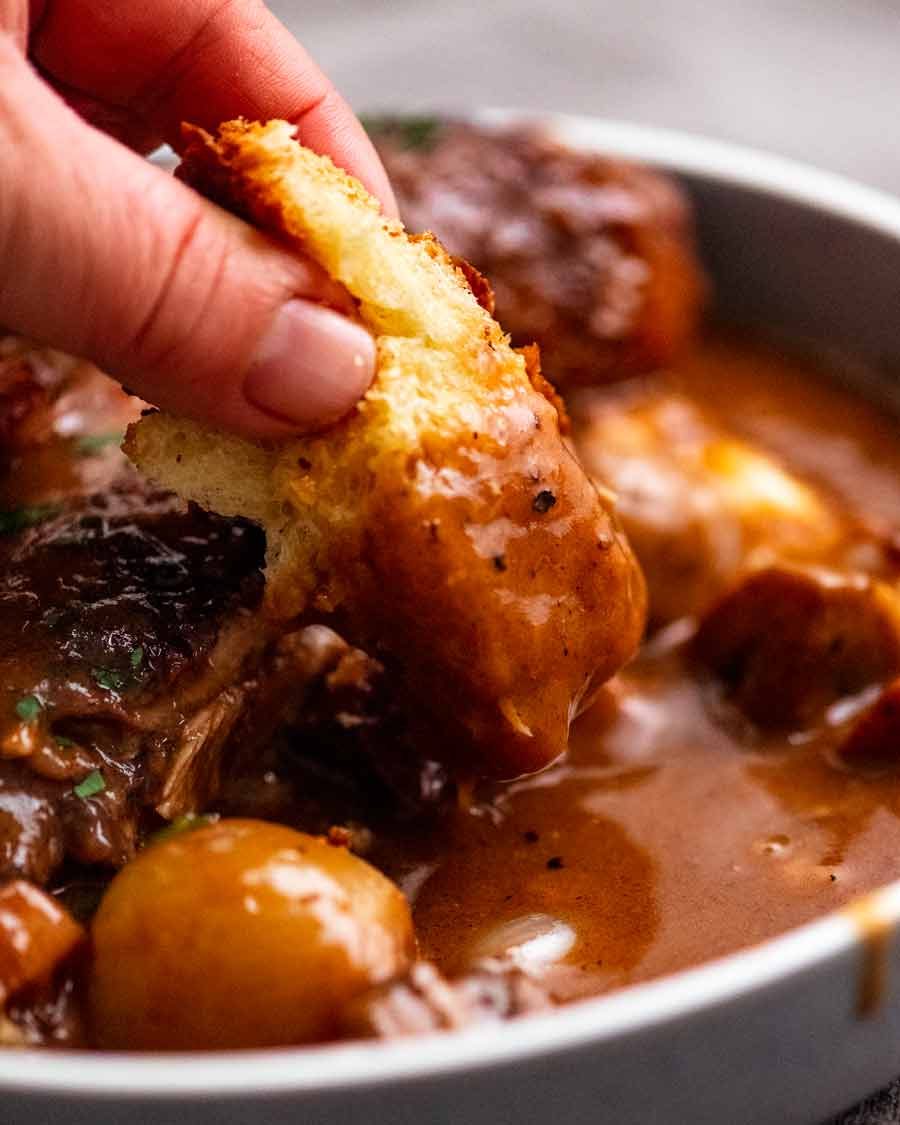 Dipping brioche into Coq au Vin sauce