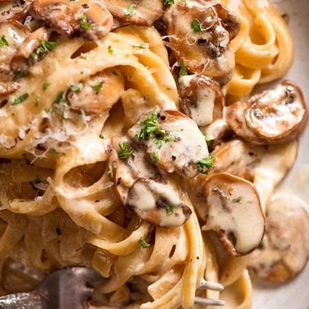 Close ups of Creamy Mushroom Pasta on a rustic handmade plate, ready to be eaten