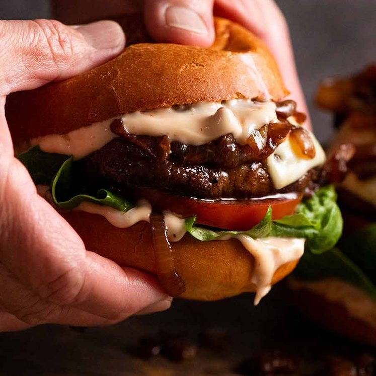 Hand holding juicy Swiss Mushroom Burgers