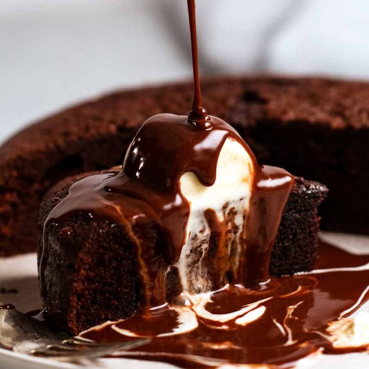 Pouring chocolate sauce over Hot chocolate fudge cake