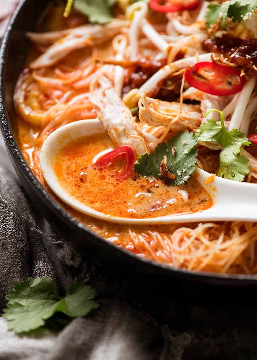 Close up of spoon scooping up Laksa soup