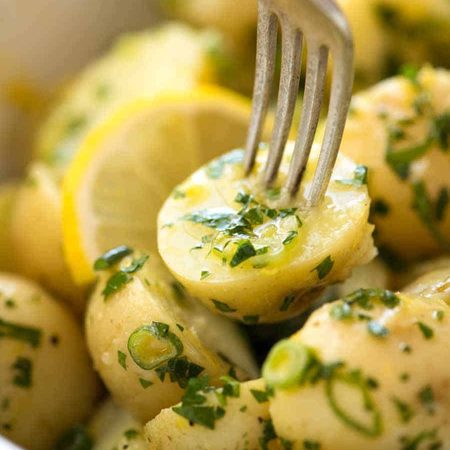 Close up of a fork picking up a no mayo Lemon Potato Salad.