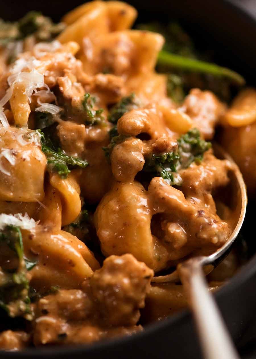 Close up of spoon scooping up Orecchiette Sausage Pasta in Creamy Tomato Sauce