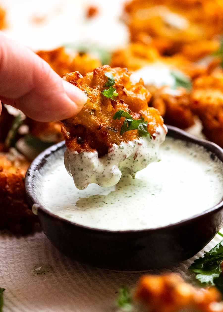 Dipping Pakora in Yogurt Mint Sauce