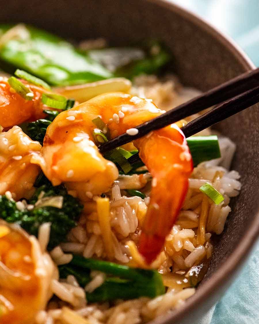 Close up photo of chopsticks picking up a prawn in a Prawn Stir Fry (Shrimp)