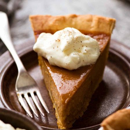 Slice of Pumpkin Pie on a plate with whipped cream