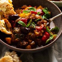 Ratatouille in a bowl with a side of crusty bread