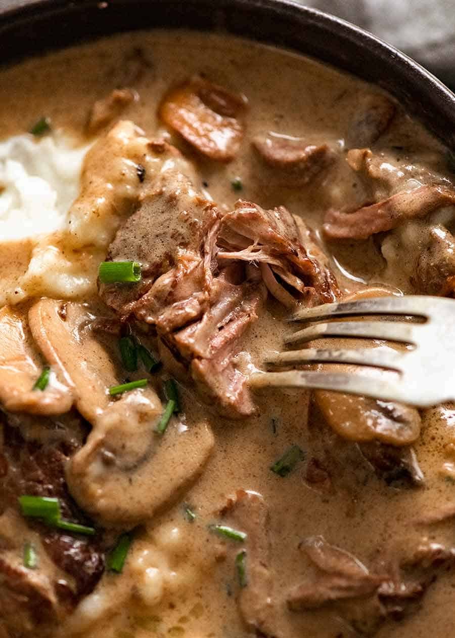 Close up showing fall apart slow cooked beef smothered din Beef Stroganoff sauce