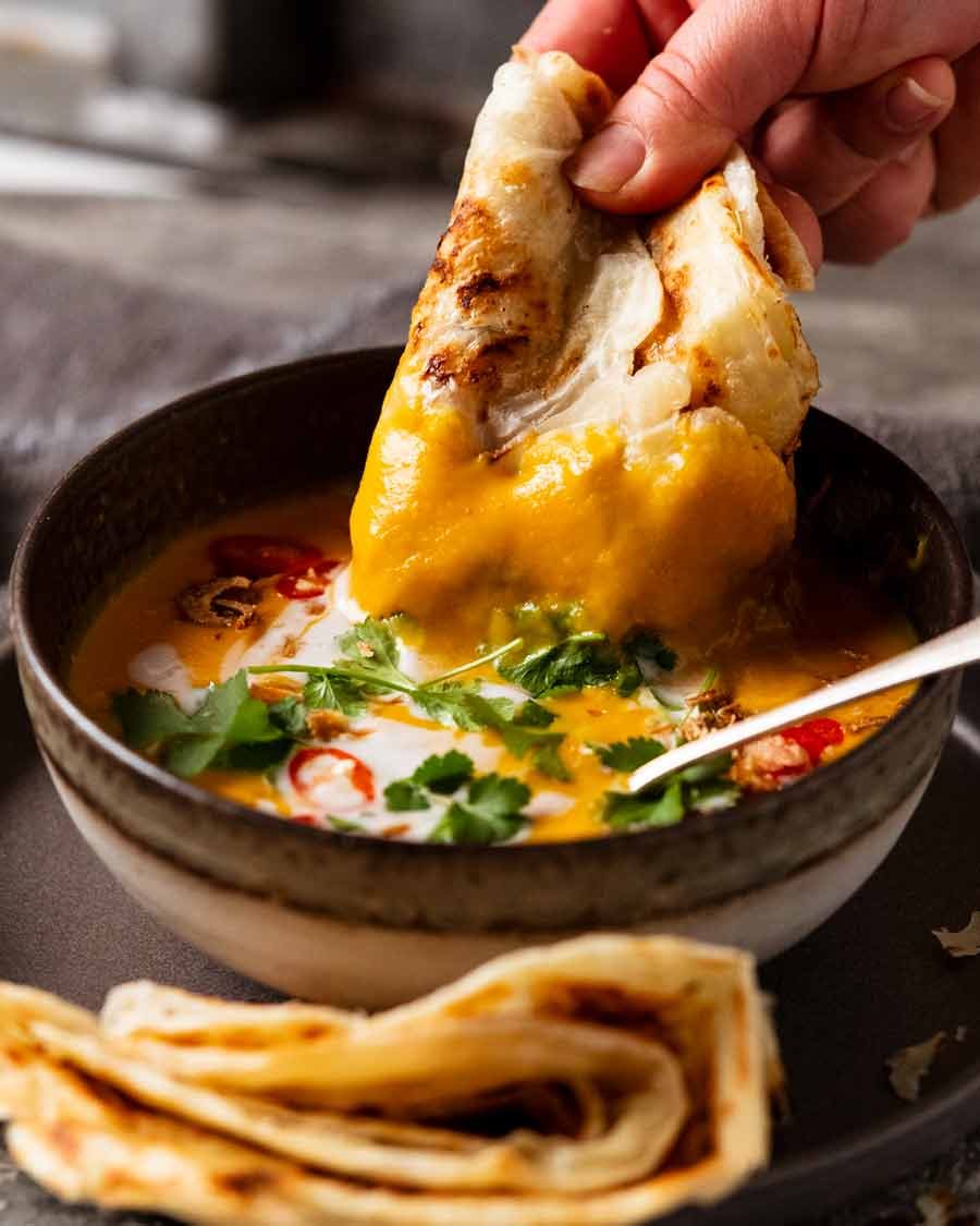 Dunking roti into Thai Coconut Pumpkin Soup